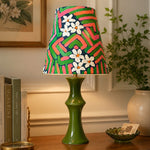 Cargar imagen en el visor de la Galería, Pink and green table lamp glowing beside framed wall art