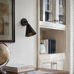 Cargar imagen en el visor de la Galería, Matte black brass wall light above books and a desk corner