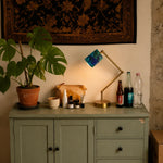 Cargar imagen en el visor de la Galería, Blue green floral table lamp lit on a console with plants and decor