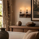 Bild in die Galerieansicht laden, Two light rustic candle wall sconce glowing above a wooden console