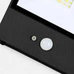 Załaduj obraz do przeglądarki galerii, Close view of motion sensor and glass diffuser on black outdoor wall lamp