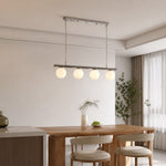 Afbeelding laden in galerijweergave, White globe chandelier in a bright dining room
