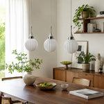 Cargar imagen en el visor de la Galería, Three ribbed glass pendants above a dining table