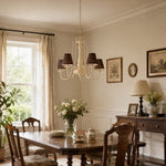 Load image into Gallery viewer, Cream and brown chandelier hanging above a rectangular dining table