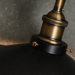 Afbeelding laden in galerijweergave, Close-up of antique brass-tone metal lamp holder and black shade