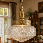 Afbeelding laden in galerijweergave, Clear glass pendant light glowing in a warm dining room