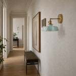 Afbeelding laden in galerijweergave, Blue milk glass brass wall sconce in a hallway