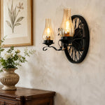 Załaduj obraz do przeglądarki galerii, Black one-head wagon wheel wall sconce above a wood console