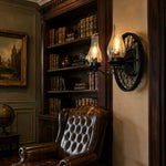 Załaduj obraz do przeglądarki galerii, Black two-light wagon wheel wall sconce installed in a vintage library