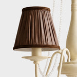 Load image into Gallery viewer, Close-up of pleated brown fabric chandelier shade with wrapped trim