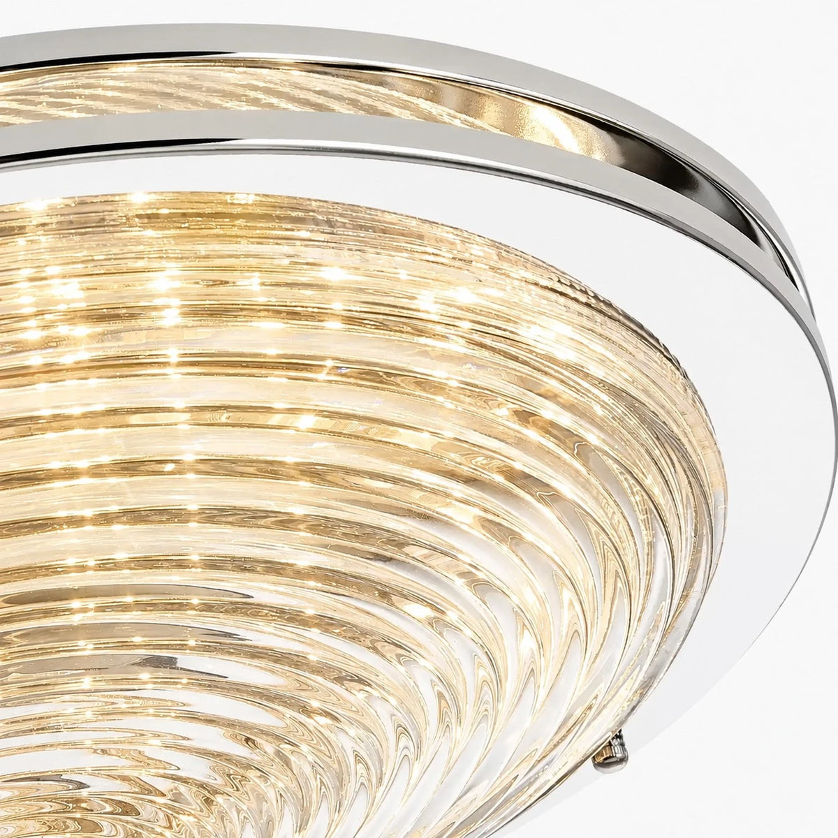 Close view of rippled glass shade and chrome rim on the ceiling light
