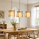 Bild in die Galerieansicht laden, Three wood frame fabric pendant lights over a dining table