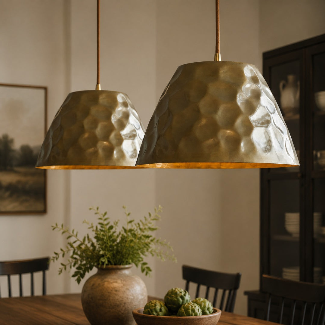 Pair of hammered brass pendant lights above a dining table
