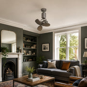 Compact ceiling fan in a green living room with sofa and fireplace