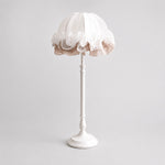 Afbeelding laden in galerijweergave, Front view of pure white ruffled fabric table lamp with sculpted metal stem