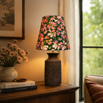 Bild in die Galerieansicht laden, Floral ceramic table lamp illuminating a vintage console by a window