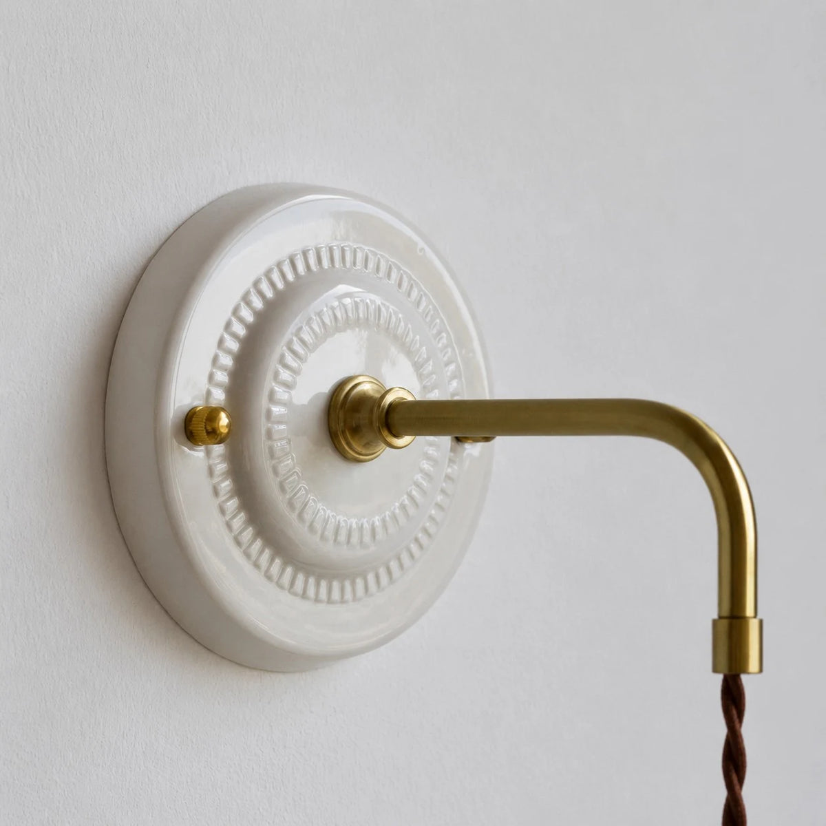 ceramic wall plate and brass arm detail