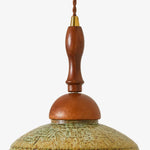 Cargar imagen en el visor de la Galería, Close view of the warm wood stem, metal collar and textured shallow shade on the wall sconce