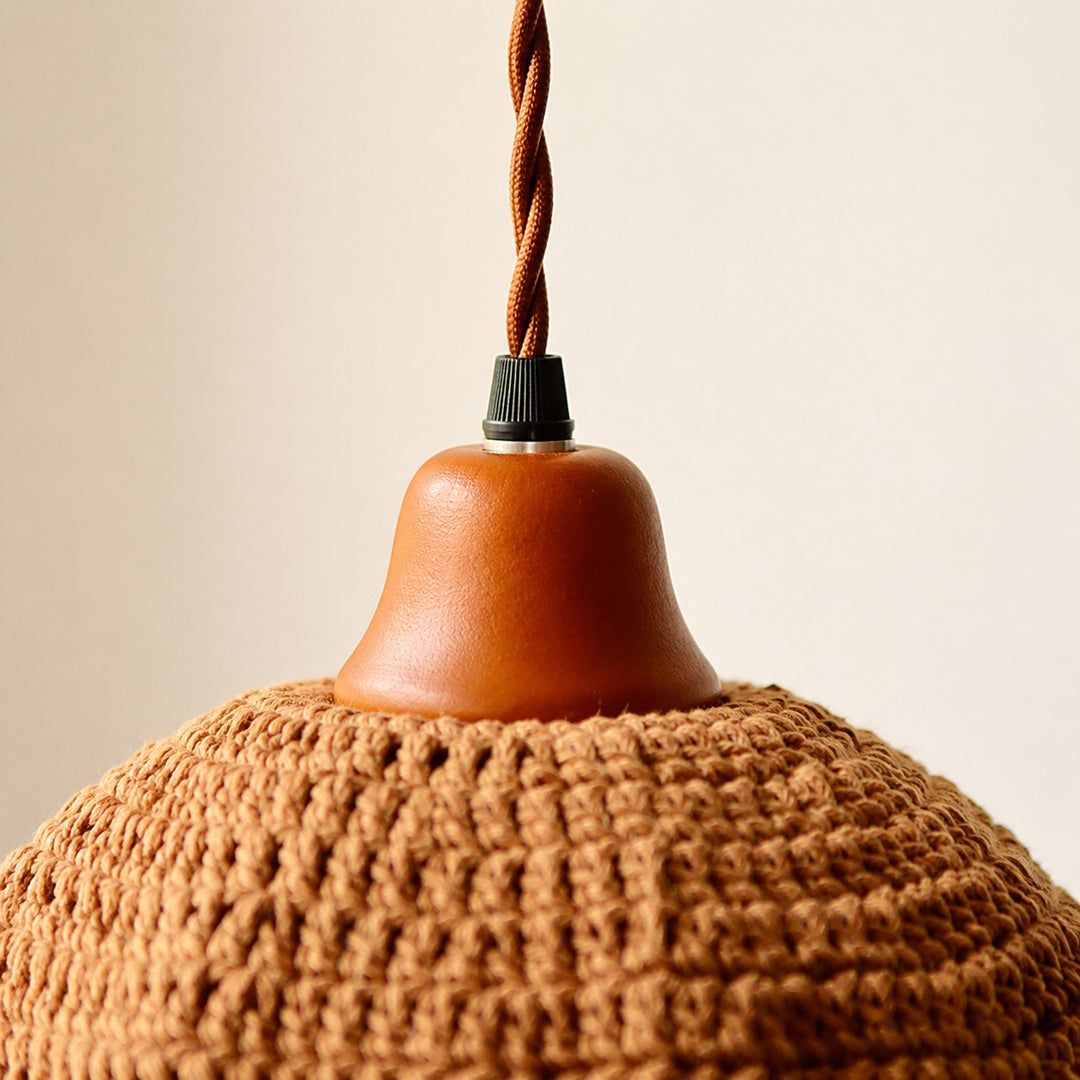 Wood lamp cup and twisted cord detail on woven pendant light