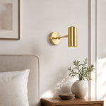 Carica l'immagine nella visualizzazione Galleria, Brass cylinder wall sconce beside a neutral upholstered bed