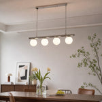 Afbeelding laden in galerijweergave, White globe chandelier above a dining table