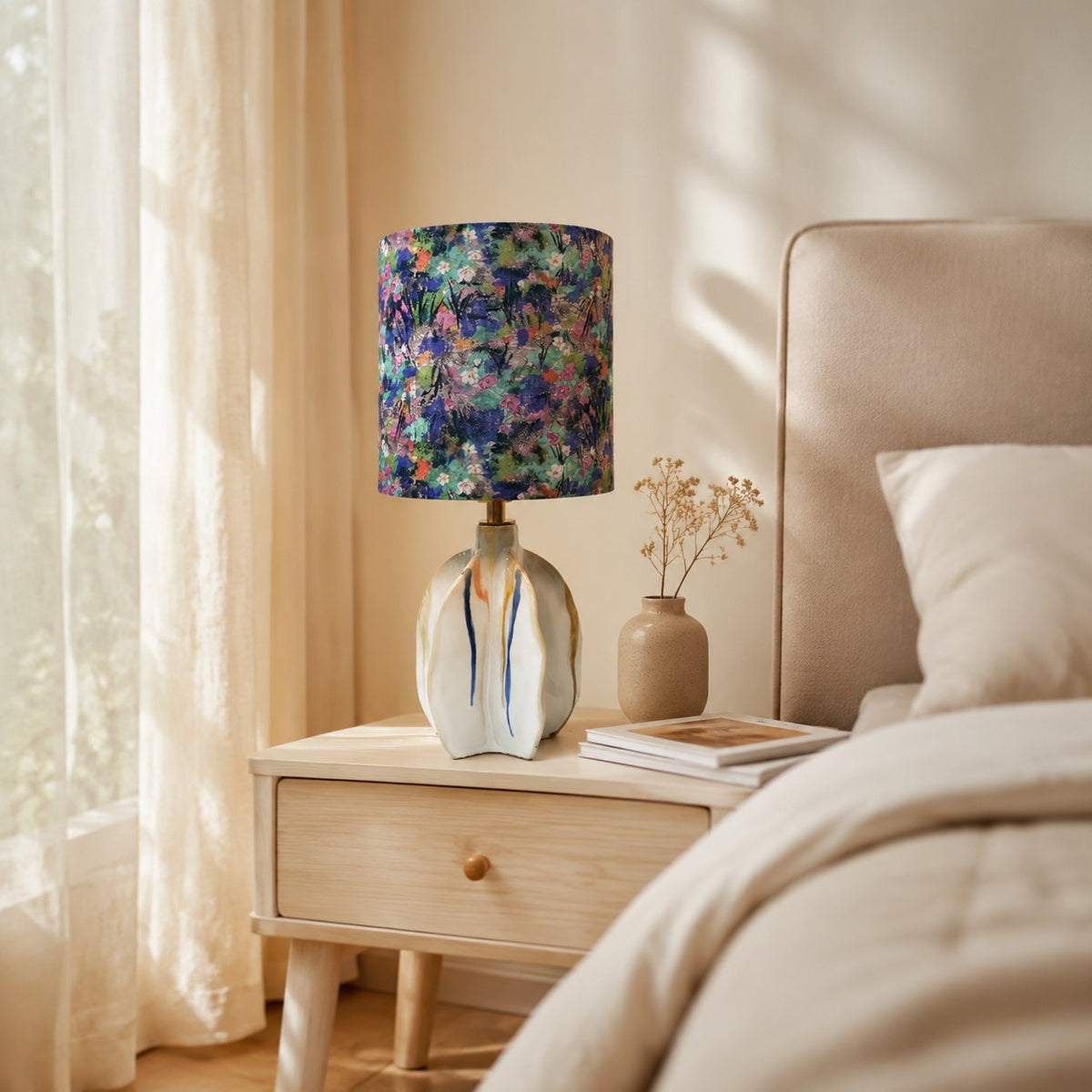 Floral fabric shade ceramic table lamp on a bedside table