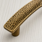 Afbeelding laden in galerijweergave, Close-up of hammered brass cabinet pull finish