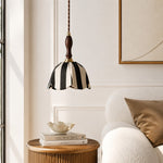 Cargar imagen en el visor de la Galería, Black and ivory fabric pendant lamp above a side table beside a lounge chair