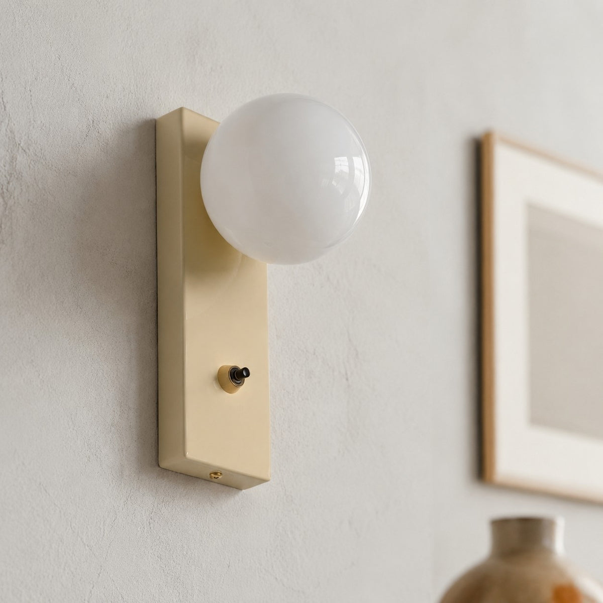 Close view of installed cream glass globe wall sconce