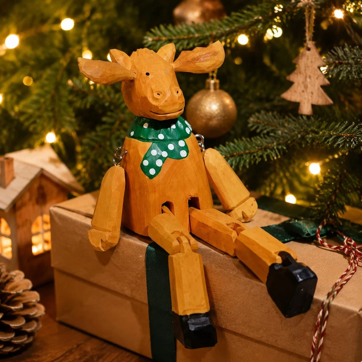 Hand-carved wooden christmas reindeer with green scarf ornament styled on a tabletop edge