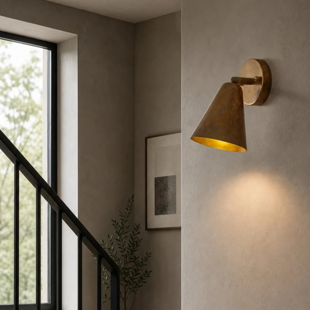 Brass cone wall lamp beside stairway