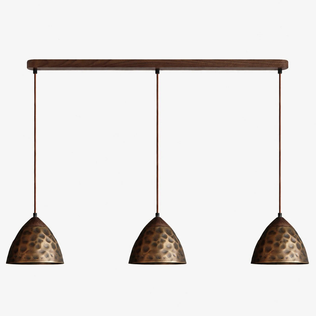 Three-light hammered copper hill pendant on walnut ceiling base