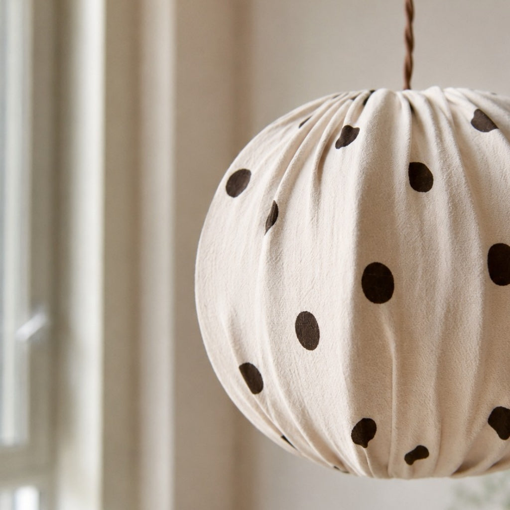 Close view of cream fabric pleats and black polka dots