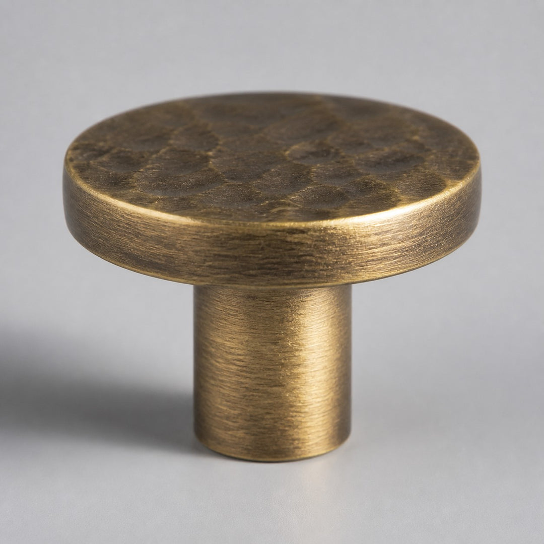 Side view of round flat antique brass cabinet knob