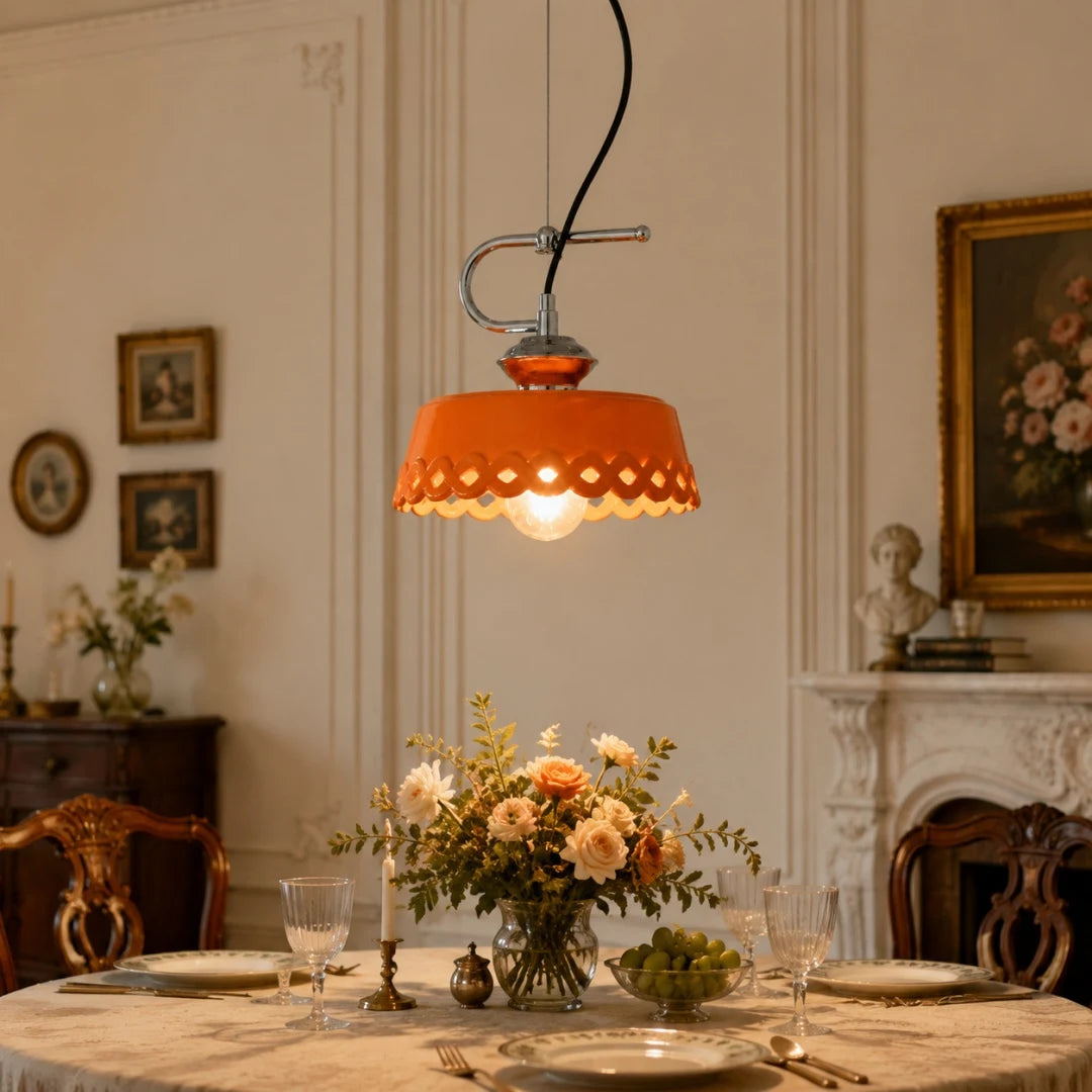 Orange metal and ceramic pendant lamp glowing over a classic dining setting