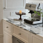 Afbeelding laden in galerijweergave, Polished silver-tone cabinet knobs installed on light kitchen cabinets