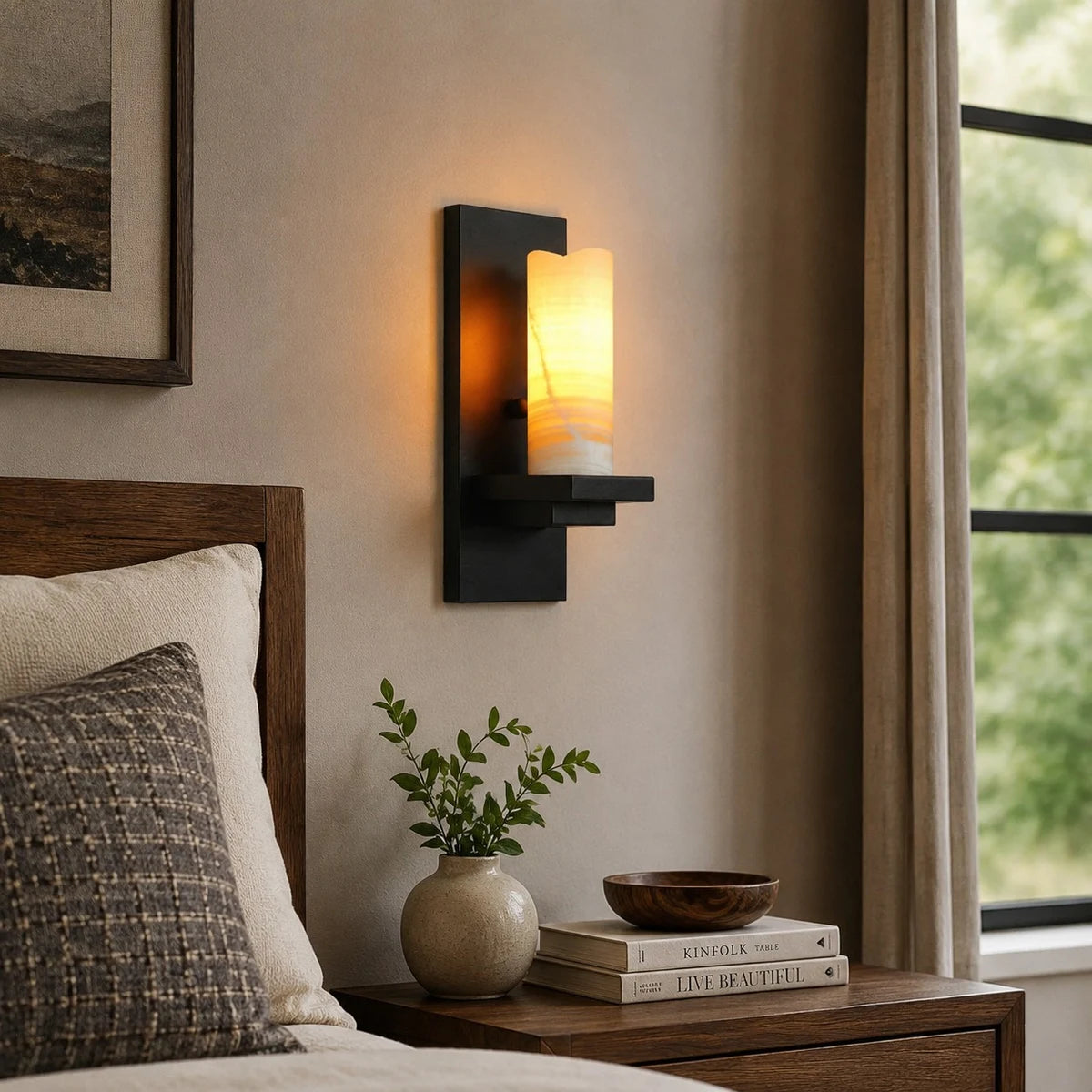 Black metal wall sconce beside a bedroom nightstand