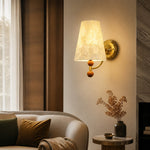 Carica l'immagine nella visualizzazione Galleria, Warm Capiz shell wall light beside a curved sofa and stone fireplace
