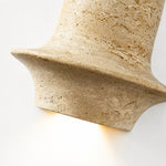 Charger l'image dans la visionneuse de la galerie, Lit close view of travertine wall lamp showing warm downward glow and honed stone edge