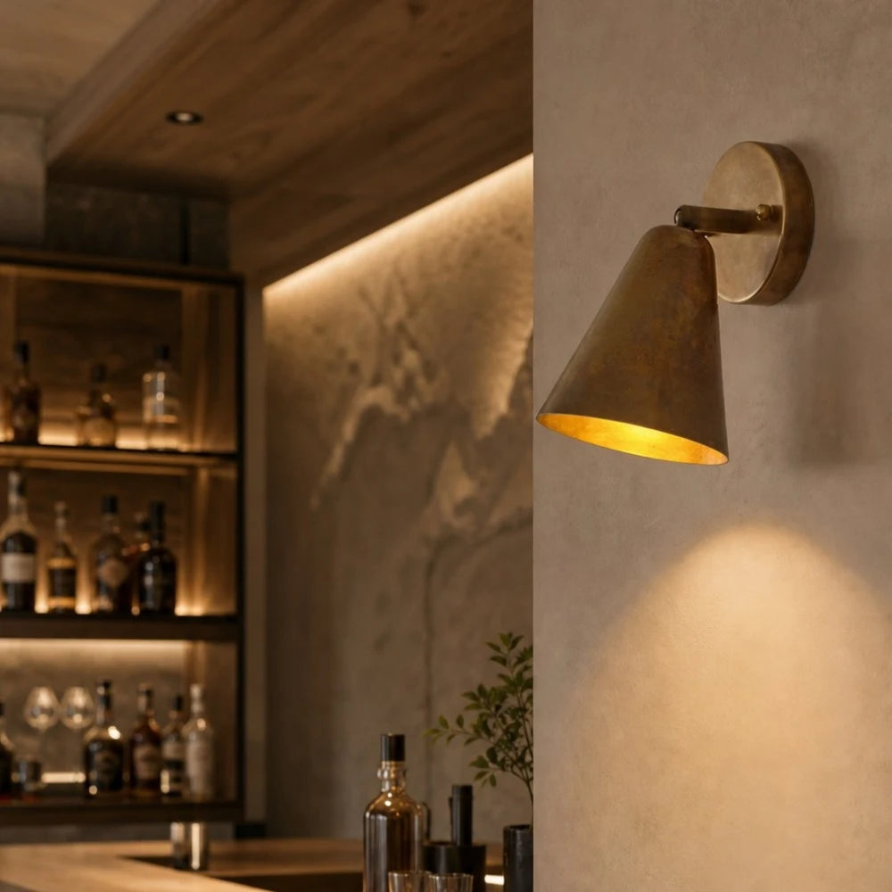 Brass cone wall lamp in a warm lounge setting