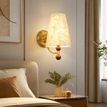 Carica l'immagine nella visualizzazione Galleria, Capiz shell wall sconce installed beside a softly upholstered bed