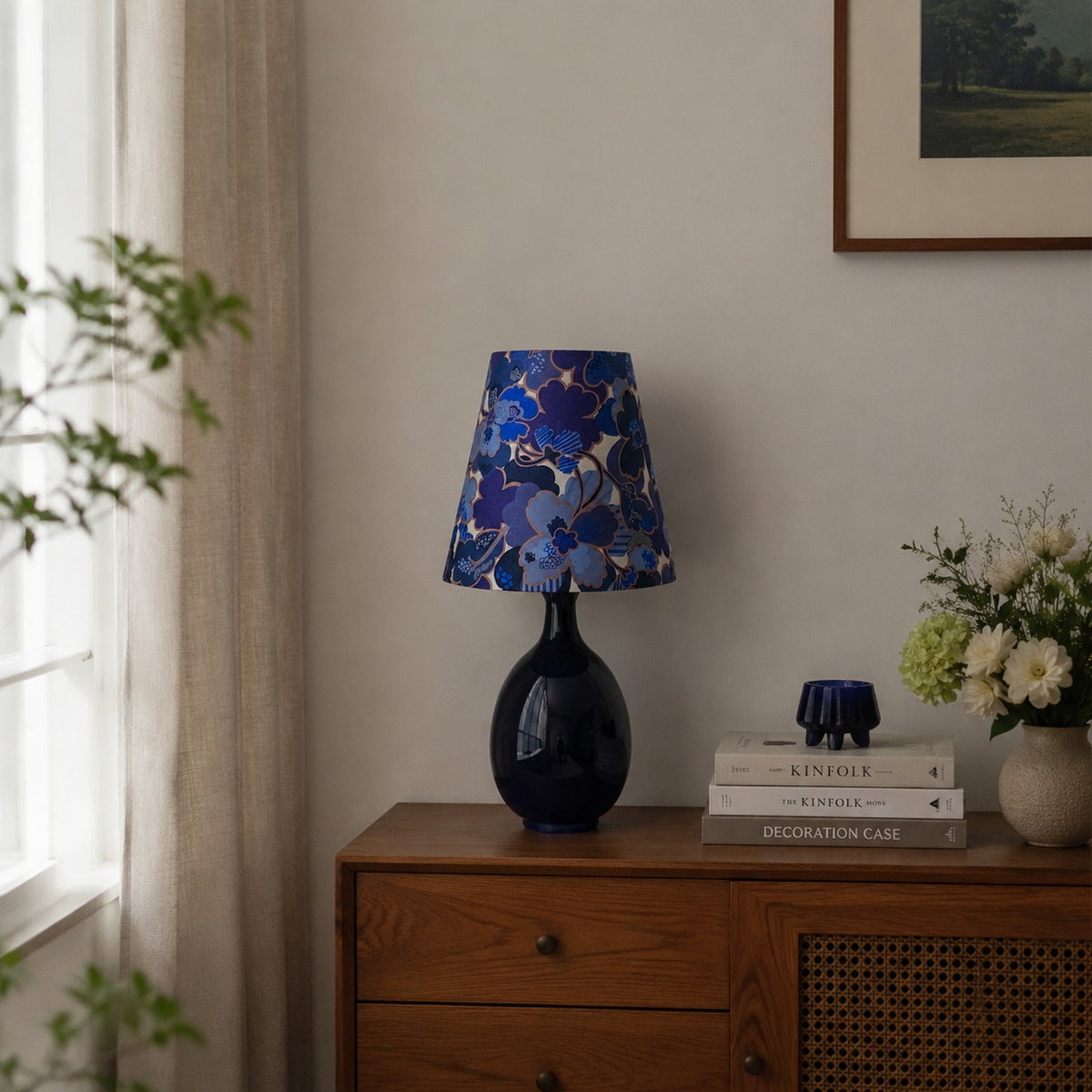 Blue floral fabric ceramic table lamp on a wooden cabinet