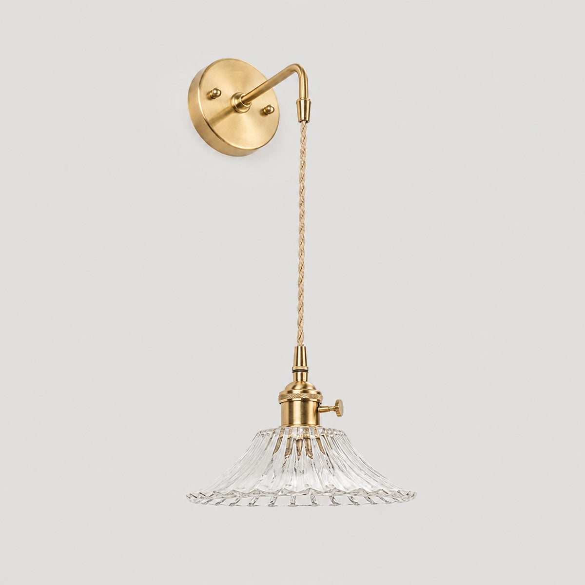 Clear shallow glass wall light with brass arm, W shade 6 cm high and 18 cm diameter