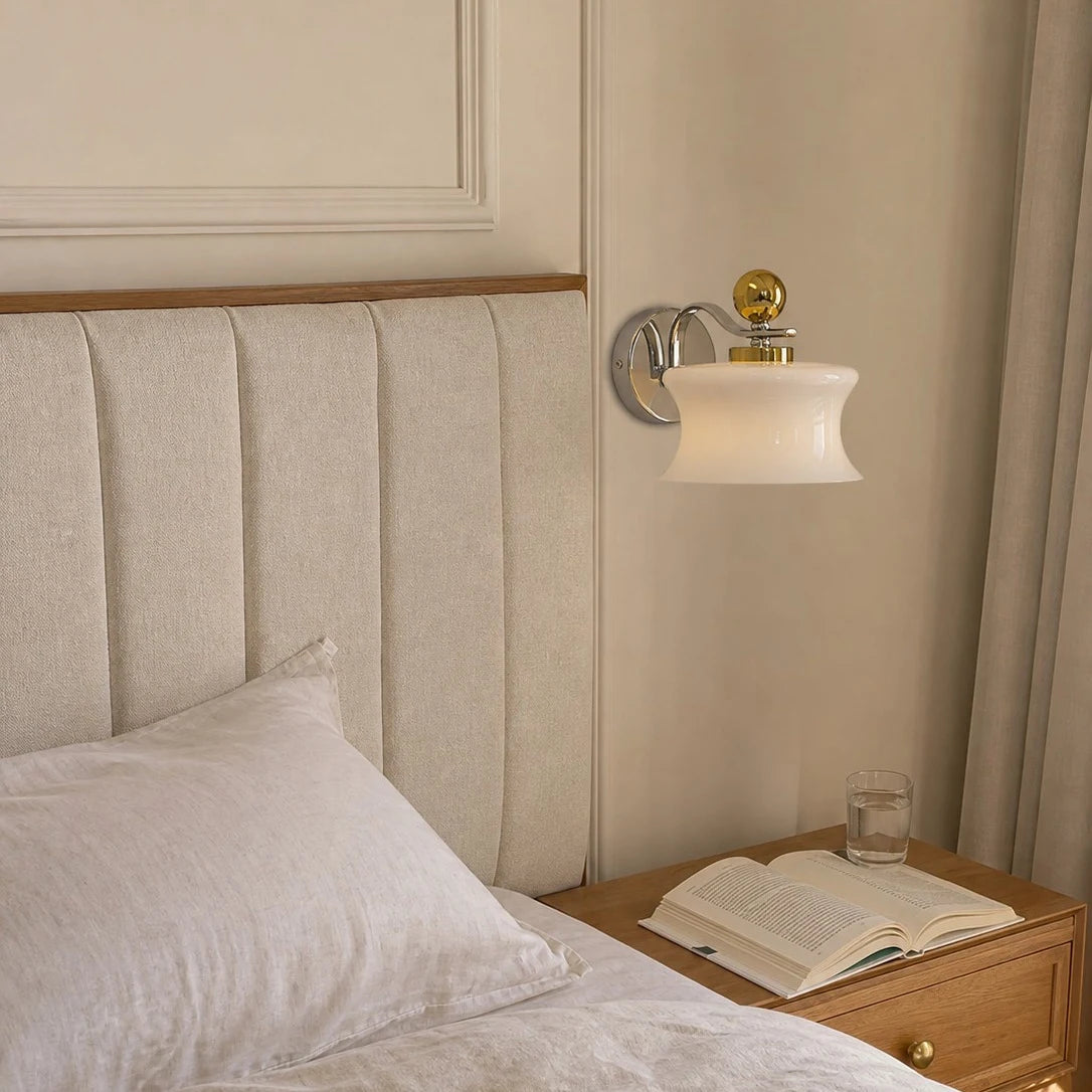 Cream glass wall lamp installed beside a bed