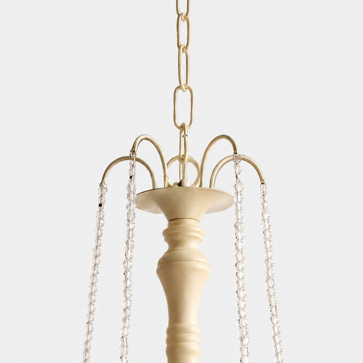Close-up of gold-tone hanging chain and crystal bead suspension details