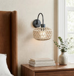 Cargar imagen en el visor de la Galería, Woven rattan wall sconce beside a warm bedroom setting