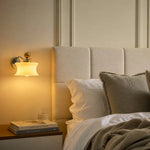 Cargar imagen en el visor de la Galería, Cream glass wall lamp casting warm bedside light