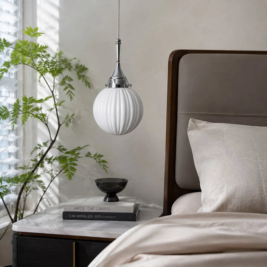Ribbed glass pendant styled beside a bed