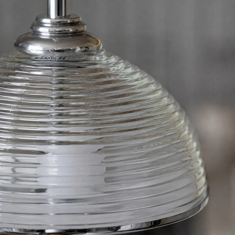 Close detail of the clear glass shade profile and metal hardware