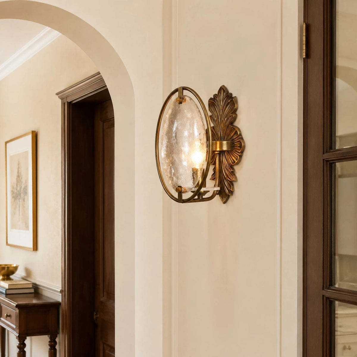 Antique brass glass wall sconce installed in a hallway